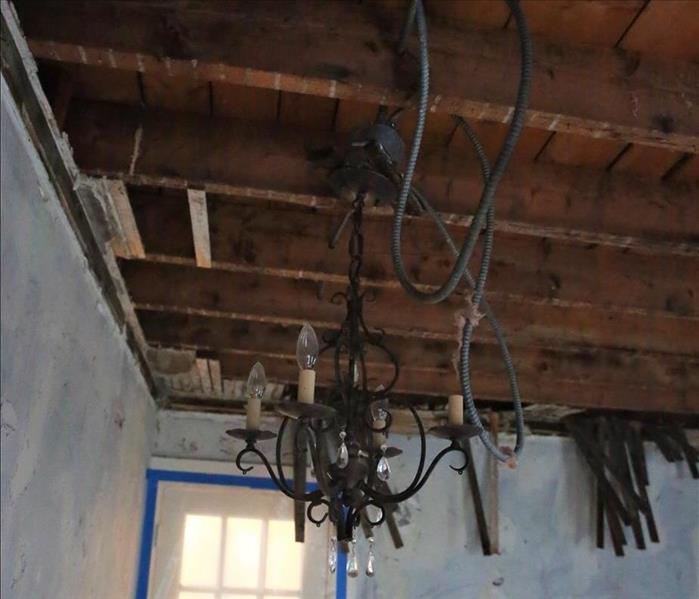A chandelier hanging from ceiling before cleanup