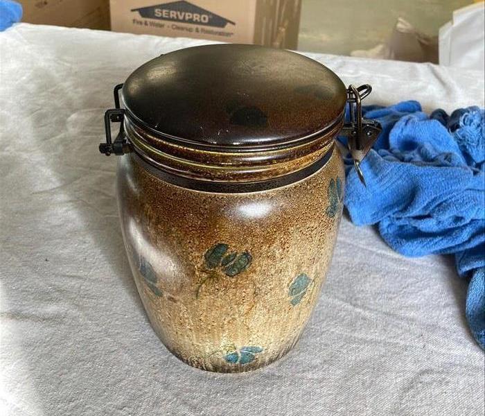 Ceramic jar heavily covered with smoke following a fire.