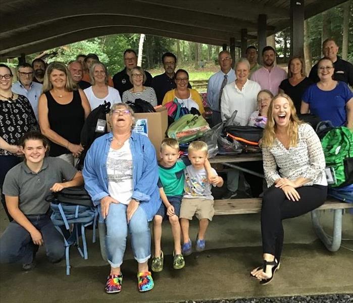 SERVPRO employees along with other members of the realtor board sitting in a covered pavilion with picnic tables