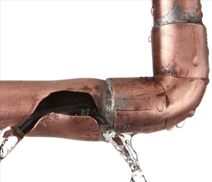 Copper pipe with a crack and leaking water.