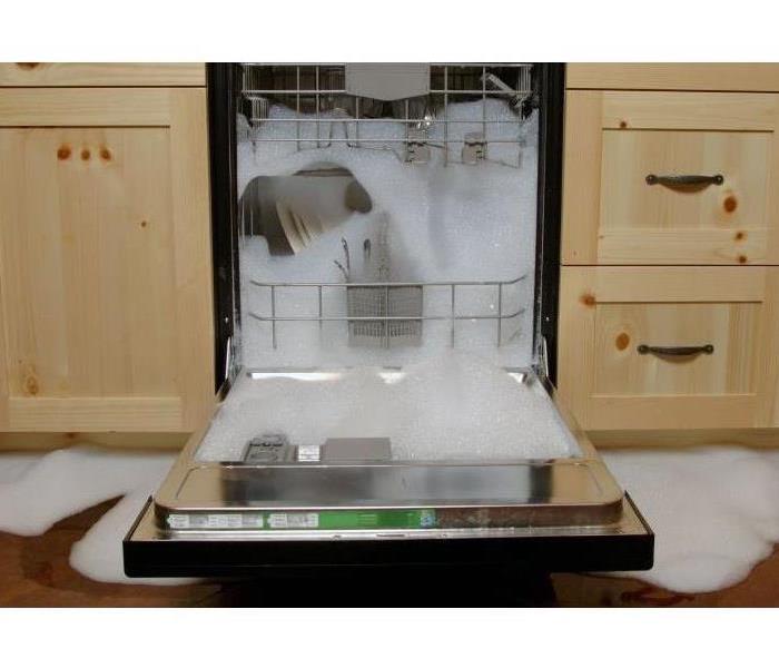 A dishwasher overflowing in a kitchen.