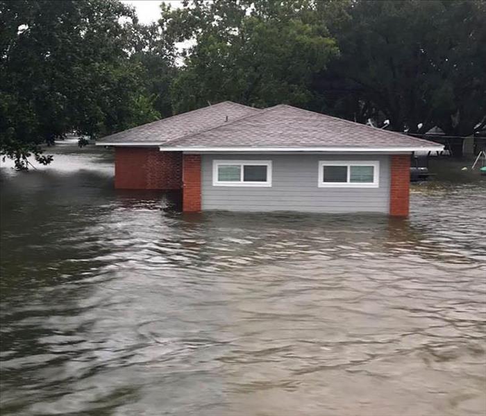 A home almost completely submerged in water during a flood